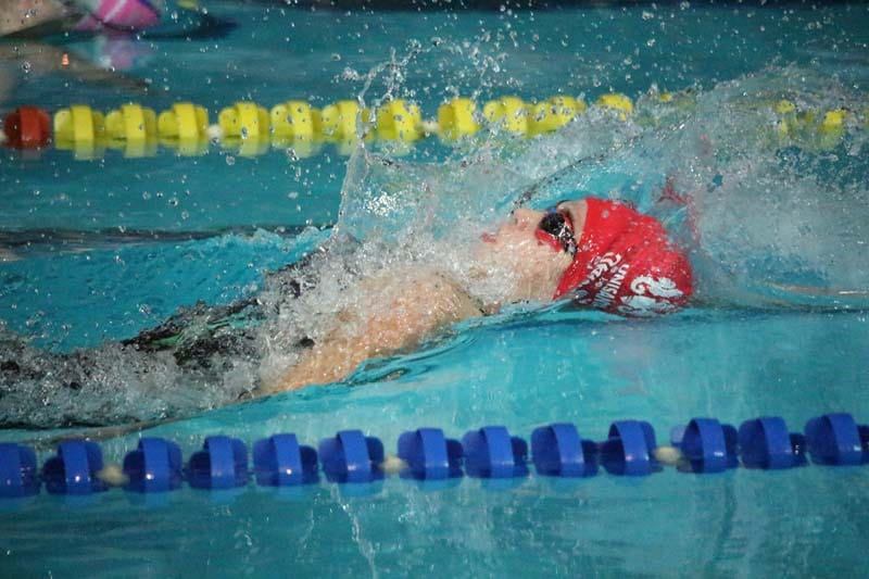 A nadadora Bianca Loureiro, de touca e óculos vermelhos, nada a prova de 200 metros costas